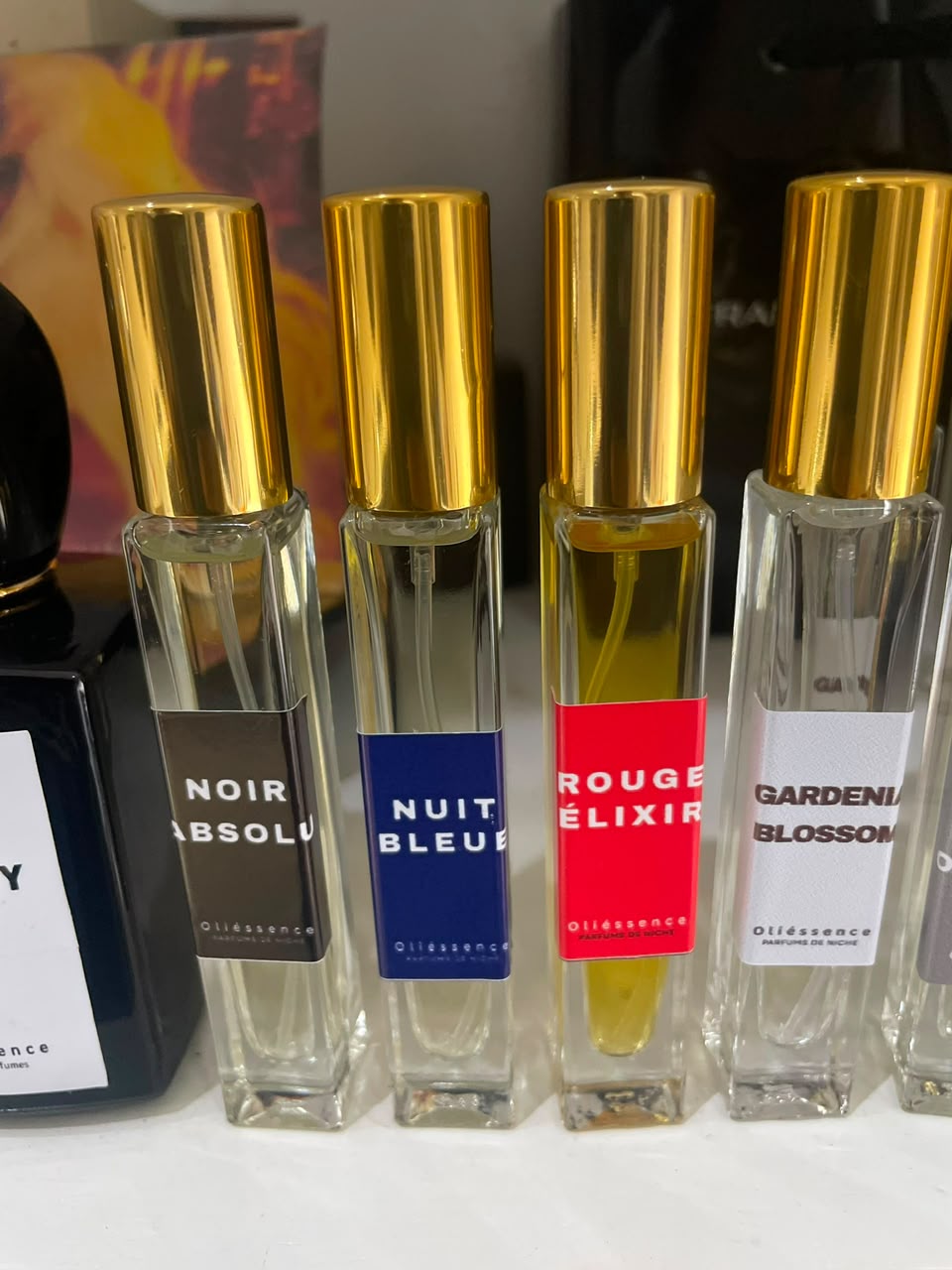 Flacon d'extrait de parfum OLIÉSSENCE posé sur une pierre claire